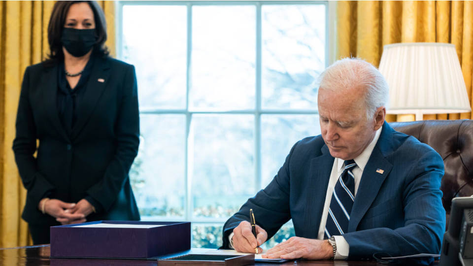 2021年3月11日，乔拜登总统在总统办公室签署美国支援计划，贺锦丽副总统在左后方陪同（白宫官方图片 Adam Schultz 摄）